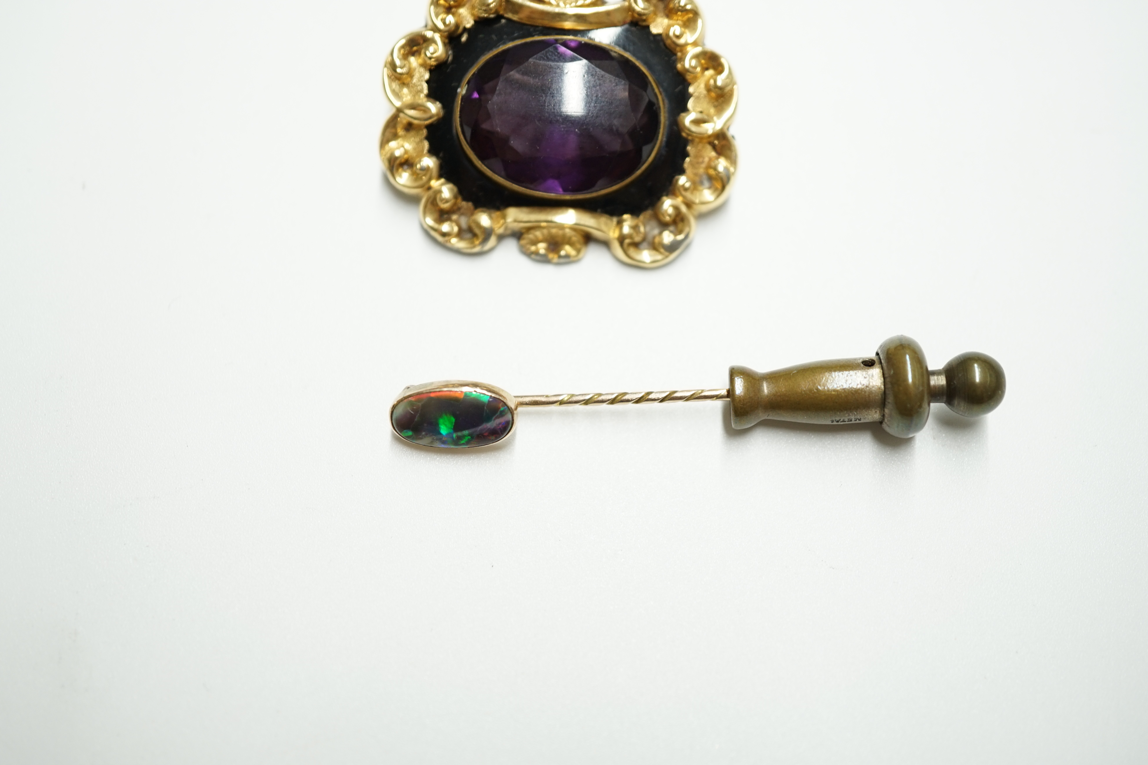 A Victorian gold plated and single stone oval amethyst paste set mourning brooch, 34mm, together with a yellow metal and black opal set stick pin. Condition - poor to fair